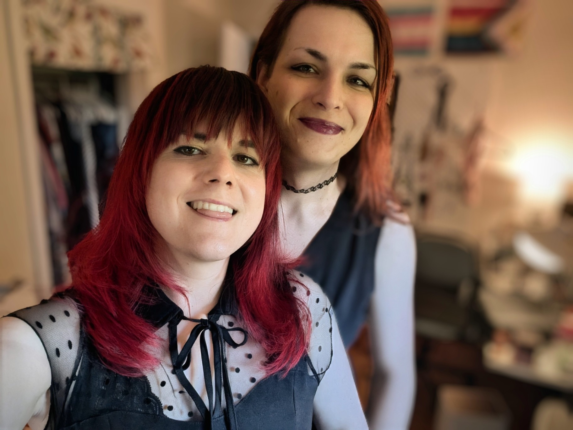 two girls wearing black dresses and smiling at the camera