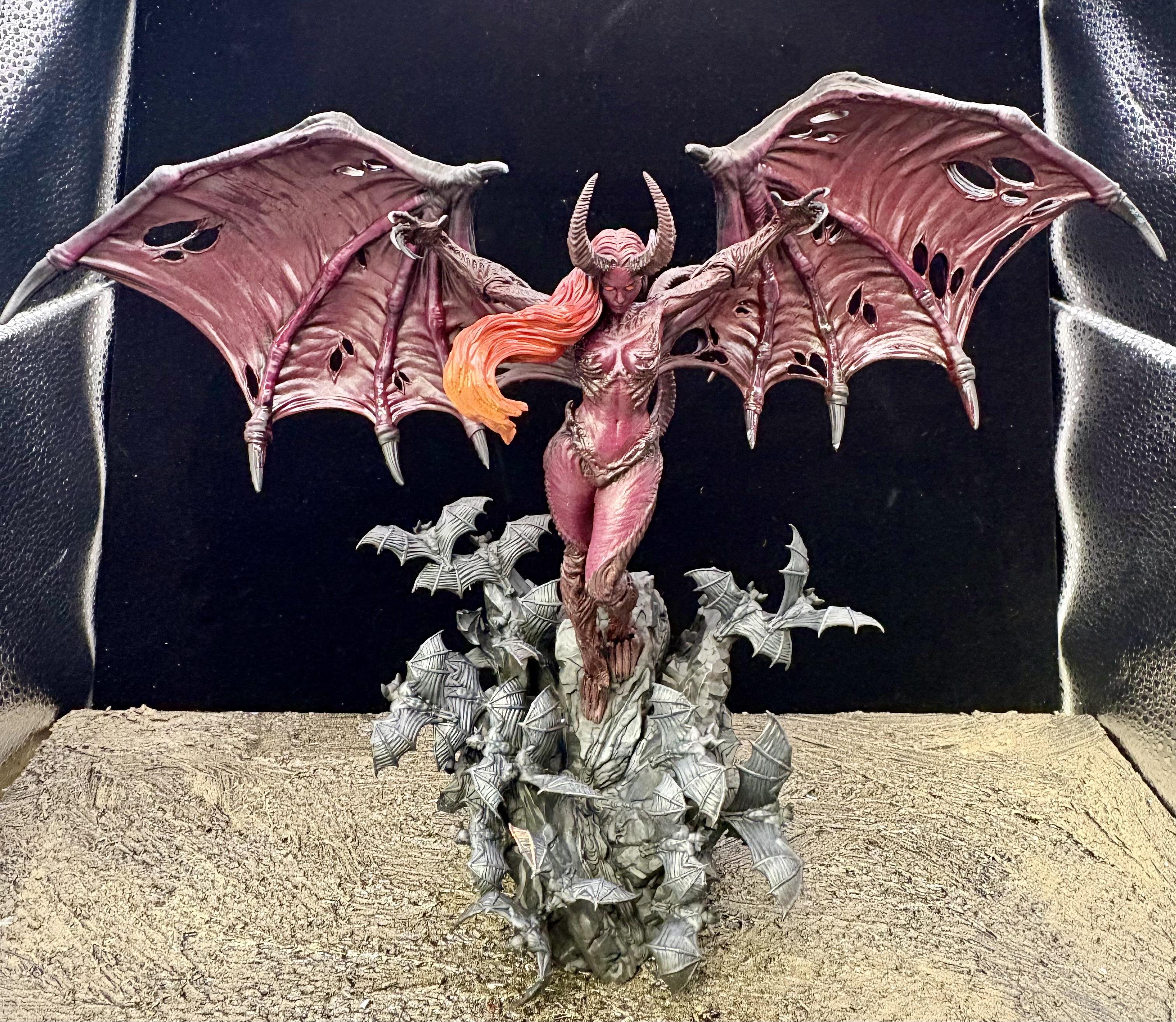 The succubus in full with a large wingspan in a light box.